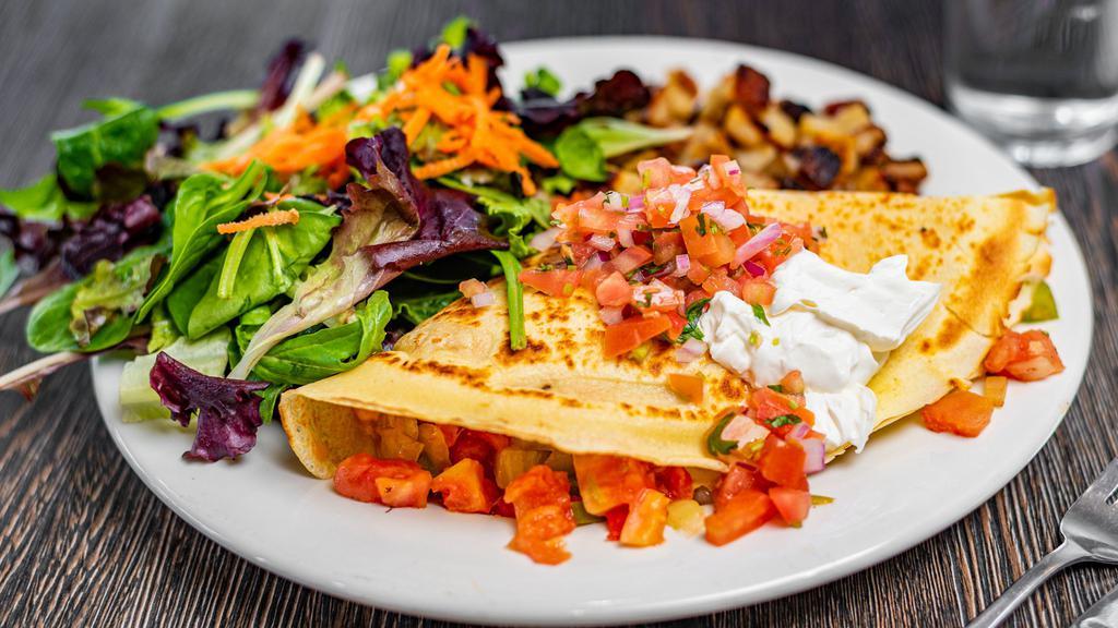Avo Crêpe · Avocado, bell peppers, tomatoes, sautéed onions and cheddar cheese topped with salsa fresca and sour cream. Add chicken for an additional charge.