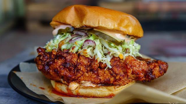 Nashville Hot Chicken Sandwich · Hand breaded chicken breast tossed in hot oil with Nashville spice mix, topped with slaw, pickles, and comeback sauce on a challah bun.