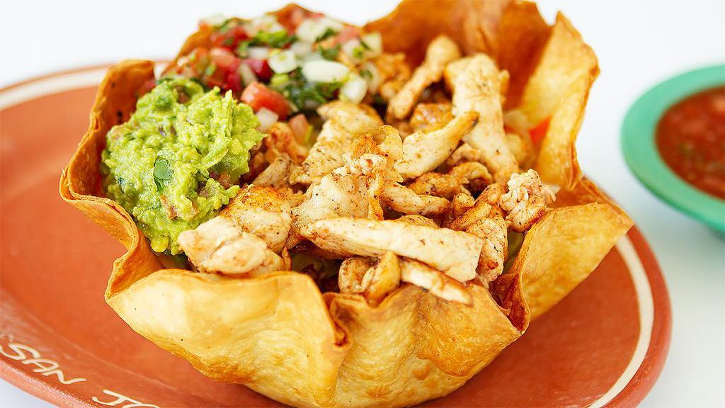 Taco Salad · Tortilla flour shell, rice, whole beans, lettuce, onion, tomatoes, cheese, sour cream, guacamole. Topped with your choice of protein.