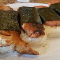 SPAM MUSUBI (2) · One piece of grilled spam rested on a bed of steamed rice, coated in musubi sauce, and wrapp...
