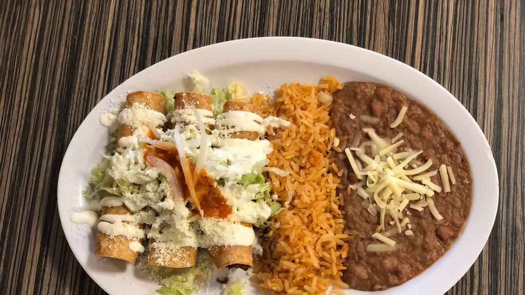 Chicken Flautas Platillo · 3 chicken flautas served with rice, beans, topped with lettuce, sour cream, cheese, onions and tomato salsa.