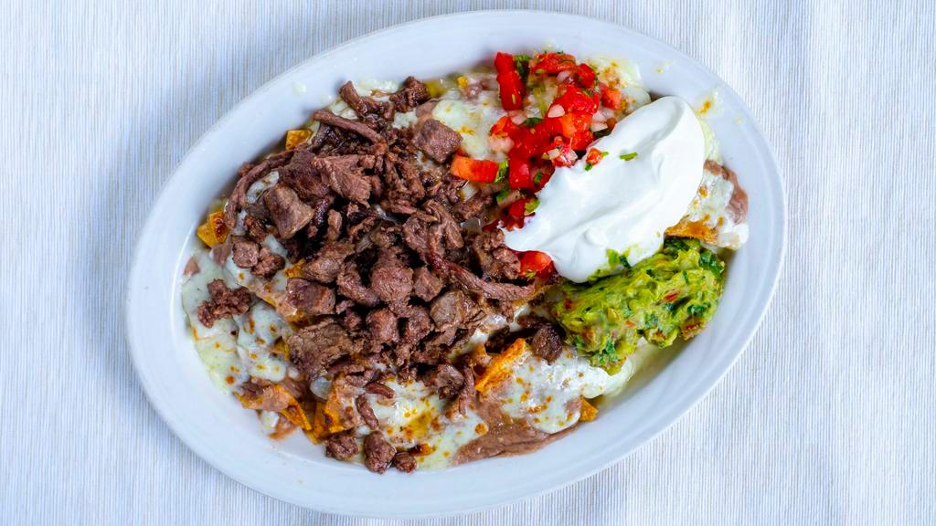 Super Nachos · Our tortilla chips layered with refried beans and melted cheese, topped with guacamole, pico de gallo and sour cream.

Choice of meat, carnitas, grilled chicken, grilled beef, ground beef