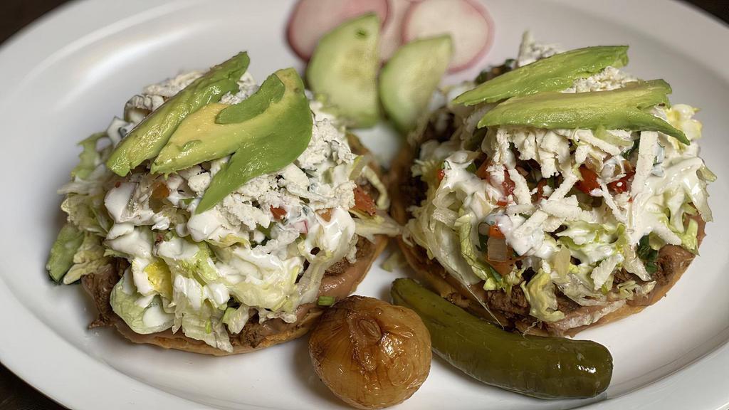 Sopes · 2 with your choice of meat, avocado, sour cream, cheese and our specialty pico de gallo.