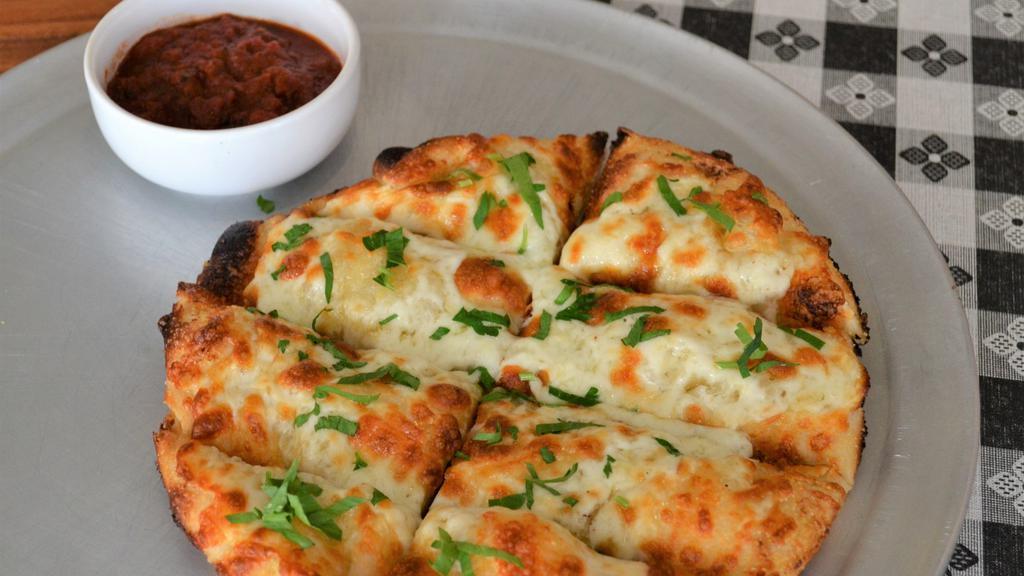 Cheesy Garlic Bread · Housemade focaccia with garlic butter, mozzarella, provolone, parmesan, romano cheese topped with fresh Italian parsley, served with a side of marinara sauce.