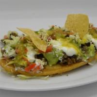 Huarache · Served with a choice of meat, re-fried beans, salsa verde, pico de gallo, lettuce, avocado, ...