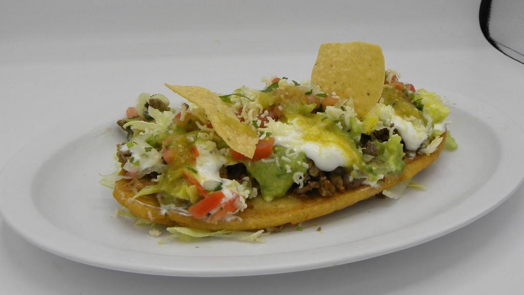 Huarache · Served with a choice of meat, re-fried beans, salsa verde, pico de gallo, lettuce, avocado, sour cream & cheese.