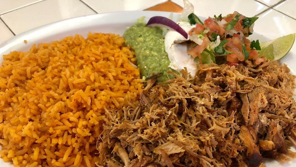 Carnitas Plato · Served with rice refried beans lettuce guacamole sour cream and pico de gallo. with your choice of corn or flour tortillas.