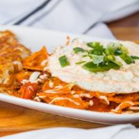 Chilaquiles · Corn tortilla chips tossed in salsa roja, tomatoes, onion, jalapeños. chorizo, topped with t...