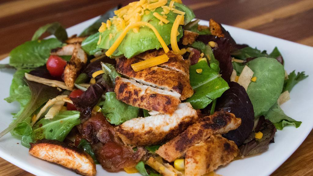Cajun Chicken Salad · Garden mix spring salad, grilled chicken, bacon, corn, cherry tomato, cheddar cheese and crispy tortilla strips. Finished with a cilantro lime vinaigrette
