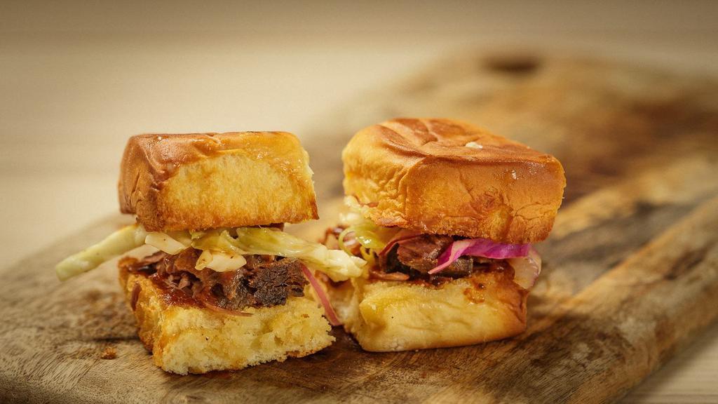 Brisket Sliders (2) · Brisket topped with slaw, pickles, BBQ sauce on a brioche roll.
