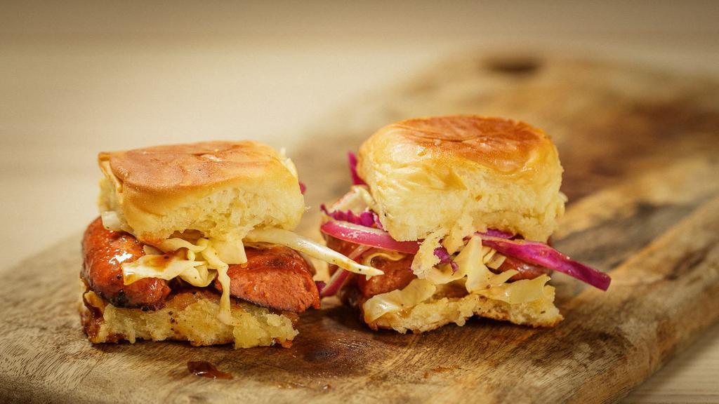Smoked Hotlink Slider · Smoked beef hotlinks  topped with slaw, pickles, BBQ sauce on a brioche roll.