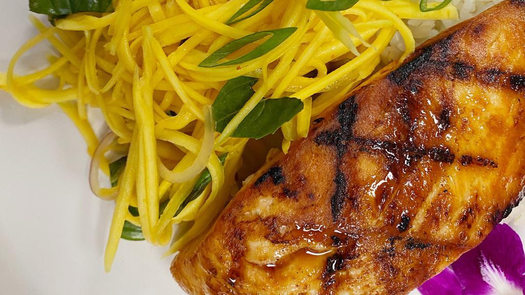 Grilled Salmon with Mango Slaw · Grilled salmon with sweet and savory mango slaw prepared with house sauce, shallots and Thai basil.