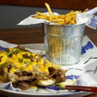 Philly Cheesesteak · Prime sirloin, house-queso, green peppers & onions.