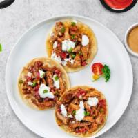 All About Al Pastor Tacos · Al Pastor served with guacamole, onions, cilantro, roasted jalapenos, radish and lime on thr...