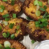 Potato skin · With cheddar cheese, bacon and garnished with green onions.