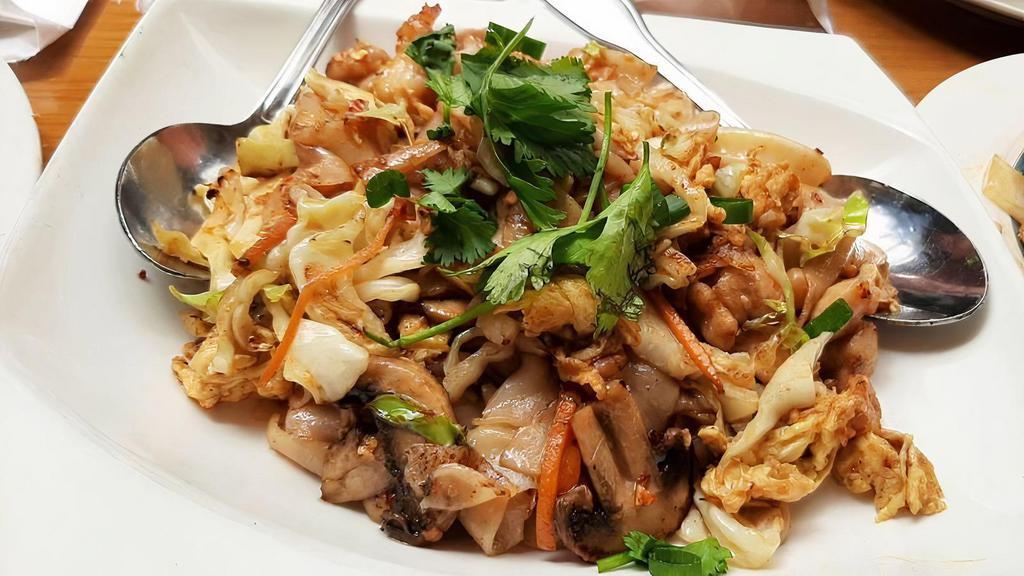 Kut Kyee Kaik (Burmese Chow Fun) · Hot and spicy. Burmese dish. Rice flat noodle, shrimp, chicken, squid, cabbage, carrot, mushroom, yellow bean, and egg sautéed with spicy sauce. Topped with green onion and cilantro.