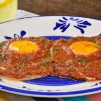 HUEVOS RANCHEROS · 2 Eggs, your style, ham, salsa, and feta cheese served atop two crispy corn tortillas and ho...