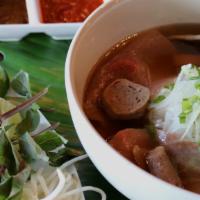 Beef Pho · 100% rare beef and brisket, tripe, meatballs, scallions, white onions, in a beef broth!