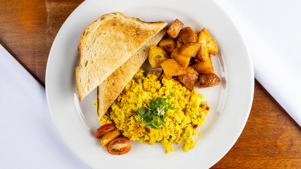 Tofu Scramble · Firm tofu and savory herbs sautéed with onion and garlic serve with your choice of breakfast potatoes, garlic roasted tomato, beans or fruits and choice of toast.