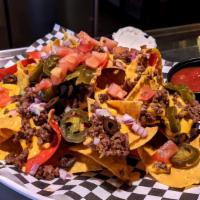 Nachos · layered with cheese, tomatoes, onions, olives & jalapenos. w/ ground beef or chicken +5.00