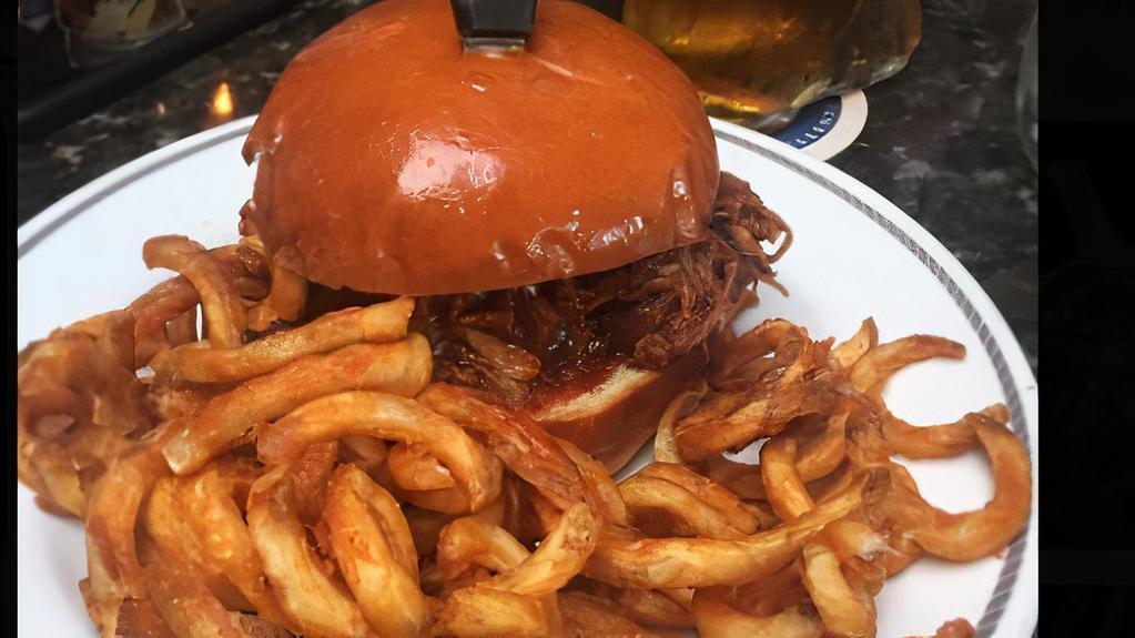 Pulled Pork · Slow roasted shredded pork shoulder served with shredded cabbage and BBQ sauce on a brioche bun.