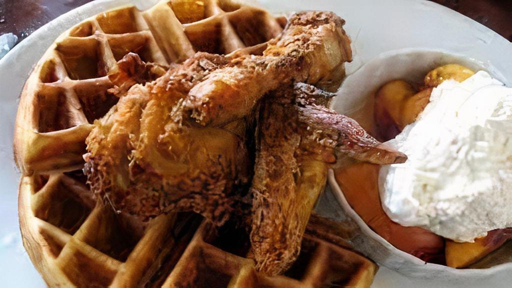 Fried Chicken and Waffles · Crispy fried chicken breast and drumstick with a fluffy Belgian waffle, and served with butter, maple syrup, and powdered sugar.