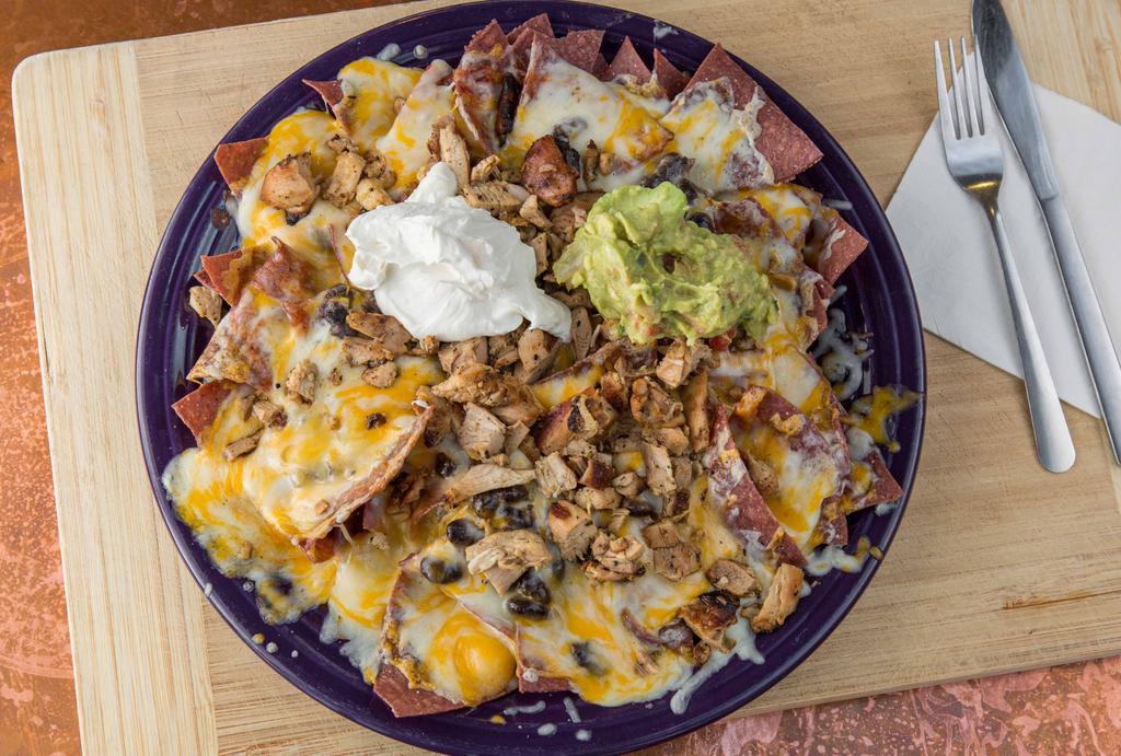 Santa Fe Nachos · Blue corn tortilla chips with black beans, chipotle Chile sauce, guacamole, sour cream, and melted cheese.