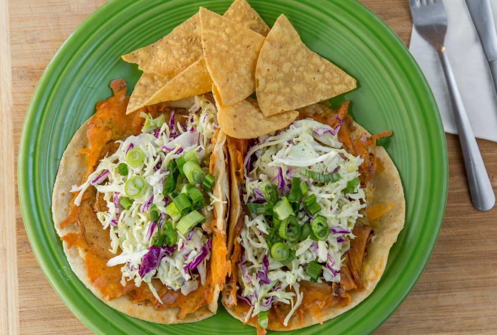 Loaded Potato Tacos (A La Carte) · Two tacos with griddled potatoes, cheese, green chile, guacamole, sour cream, cabbage slaw & green onions.