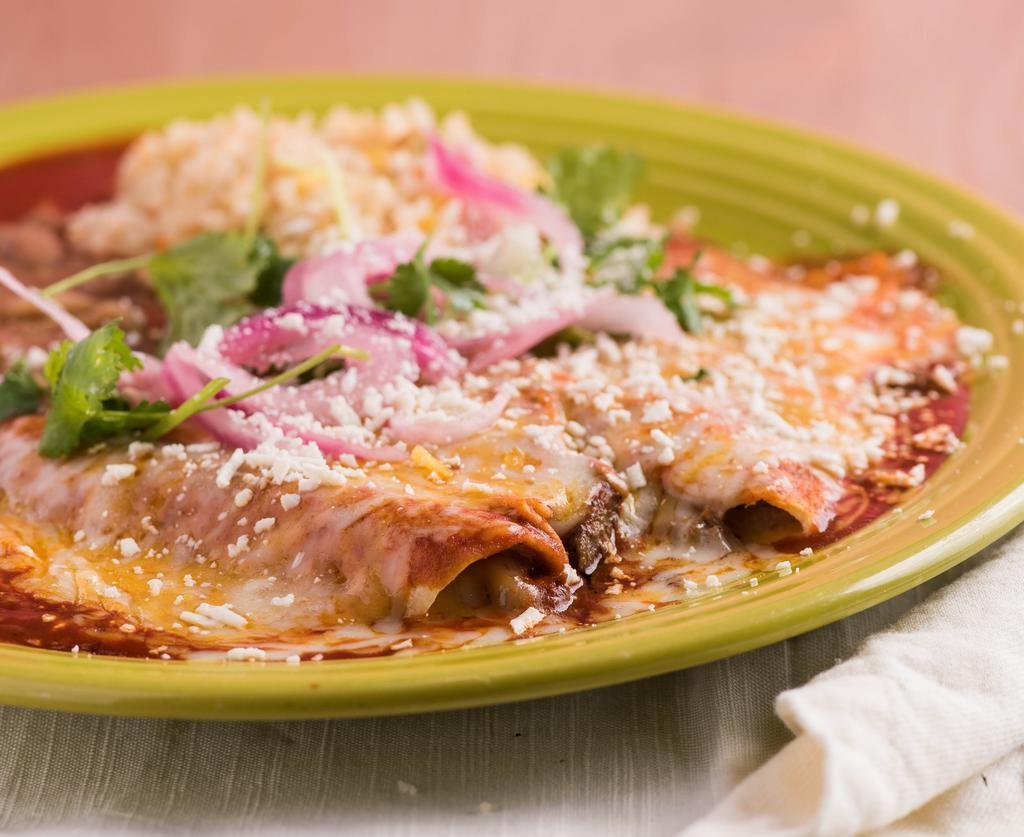 Red Chile Enchiladas · Corn tortillas with three cheeses, baked in our red chile sauce, served with citrus-marinated onions & cilantro sprigs.