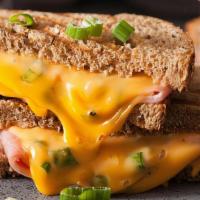 The Grilled Cheese Sandwich · Classic american cheese and pepper jack cheese, crispy bacon, and tomatoes on grilled Parmes...