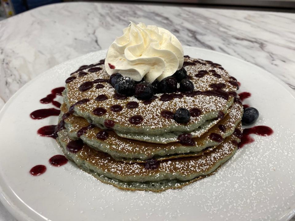 BLUEBERRY PANCAKES · Three blueberry batter pancakes, fresh blueberries, blueberry glaze, powdered sugar, whipped cream.