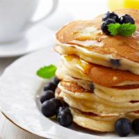 Banana & Blueberry Pancakes · Perfectly fluffy pancakes topped with bananas and blueberries served with a side of butter a...