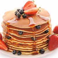 Strawberry & Blueberry Pancakes · Perfectly fluffy pancakes topped with strawberries and blueberries served with a side of but...
