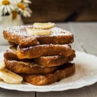 Banana French Toast · Fresh baked bread dipped in a rich egg batter topped with bananas with a side of butter and ...