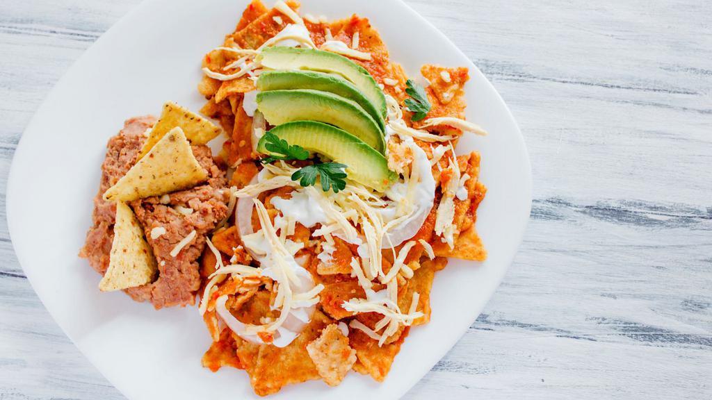 Chilaquiles · Fresh eggs, tomato sauce, bacon, pico de gallo, cheese, avocado, and sour cream served on a bed of homemade tortilla chips.