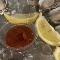 Raw Oysters (Qty. 6) · Shucked to order and served in a half shell with lemons and hot sauce.