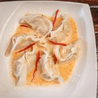 Dumpling  · Steamed Dumplings Chicken and vegetable with red curry sauce, topped with diced bell peppers...