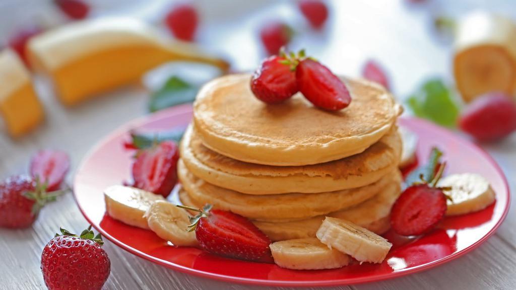 Strawberry Banana Pancake · 3 Buttermilk pancakes freshly prepared and cooked to perfection. Topped with fresh strawberries and banana slices and served with syrup and hint of butter.