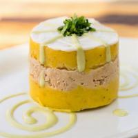 Causa · Two layers of whipped yellow potatoes made with aji amarillo chili, served with a tasty laye...
