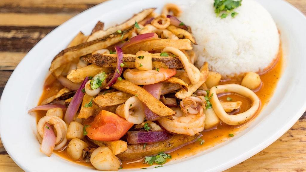 Saltado de Mariscos · Stir fried mixed seafood, onions, tomatoes, fried potatoes, cilantro and soy sauce, served with garlic white rice.