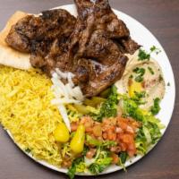 Lamb chops · lamb chops, served with rice, Salad, grill Tomatoes, fresh onion and hummus or baba ghanoush.