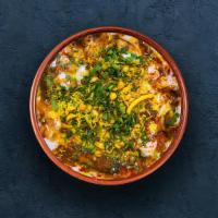 Samosa Chaat · Crispy pastry dumplings rolled into bite-size pieces in chickpea curry, seasoned with herbs,...