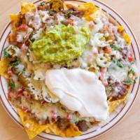 La Azteca Nachos with Meat · Crispy corn tortilla chips covered with jalapenos, beans, melted cheese, tomatoes, sour crea...
