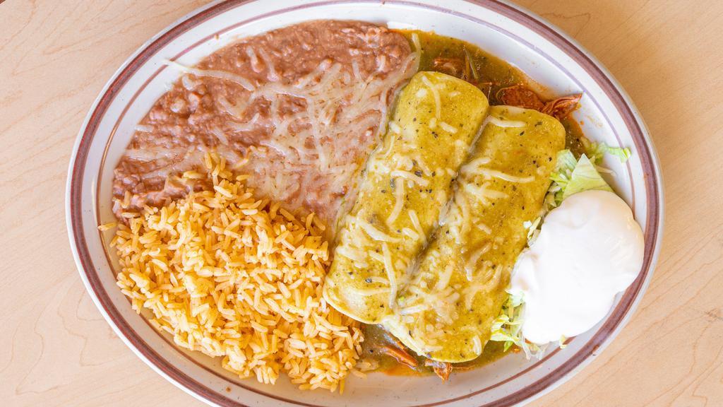 Enchiladas Suizas · Two corn tortillas rolled and filled with our delicious seasoned chicken meat, covered with our salsa Verde, made with tomatillos, and topped with melted cheese, served with rice, beans and sour cream.