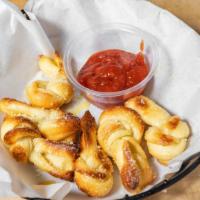 Garlic Knots · Six twisted breadsticks with garlic butter, garlic and Parmesan cheese.