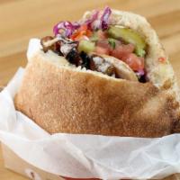 Pita Sandwich · Served with hummus, Israeli salad, cabbage, tahini, pickles and your choice of protein.