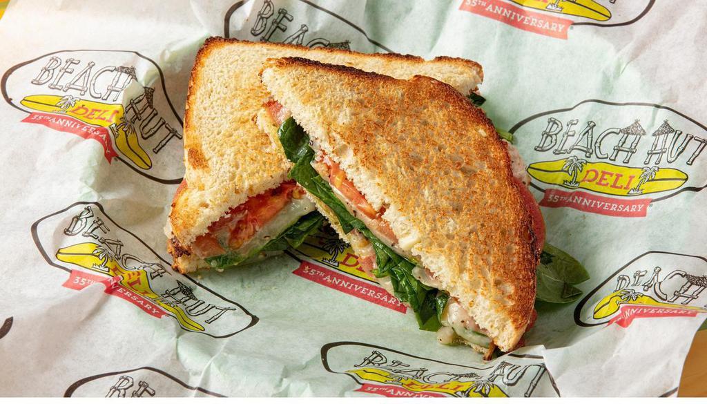 Cali Caprese · Melted monterey jack cheese, balsamic vinaigrette, pesto, tomatoes & spinach on toasted garlic cheese bread