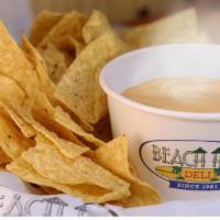 Shaka Nachos · Tortilla chips with a side of nacho cheese for dipping.