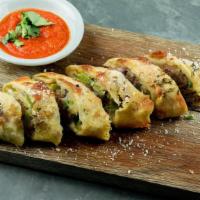 Patxi's Sausage Roll · Garlic-fennel sausage, bell-peppers, red onion and mozzarella rolled in rosemary parmesan do...