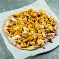 ROASTED CARAMEL APPLE PIZZA · Lightly sweetened pizza dough topped with cream cheese, roasted apples & finished with caram...